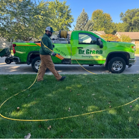 Certified technician Tyler spraying a lawn, providing professional lawn care service.