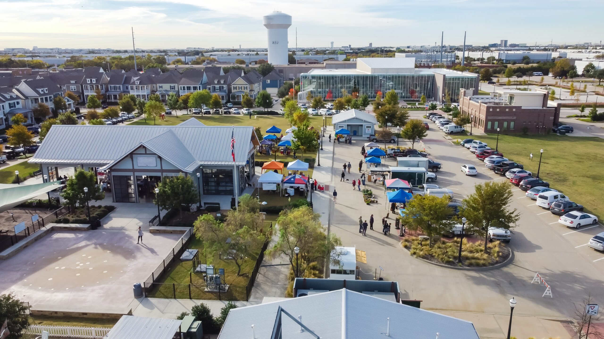 Market scene in Coppell with green and weed-free lawns in the background, showcasing Coppell lawn care and mosquito control.