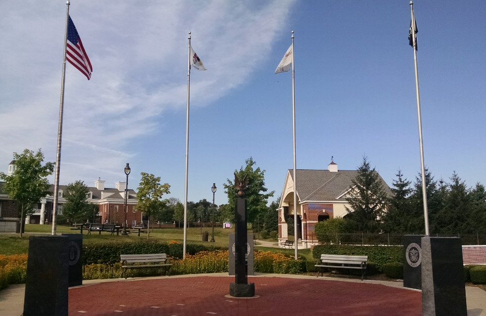 Veterans memorial statue at New Lenox Commons Park surrounded by green and weed-free lawn.