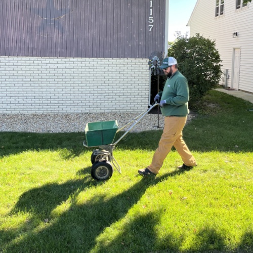 Certified technician applying slow release fertilizer for New Lenox Lawn Care.
