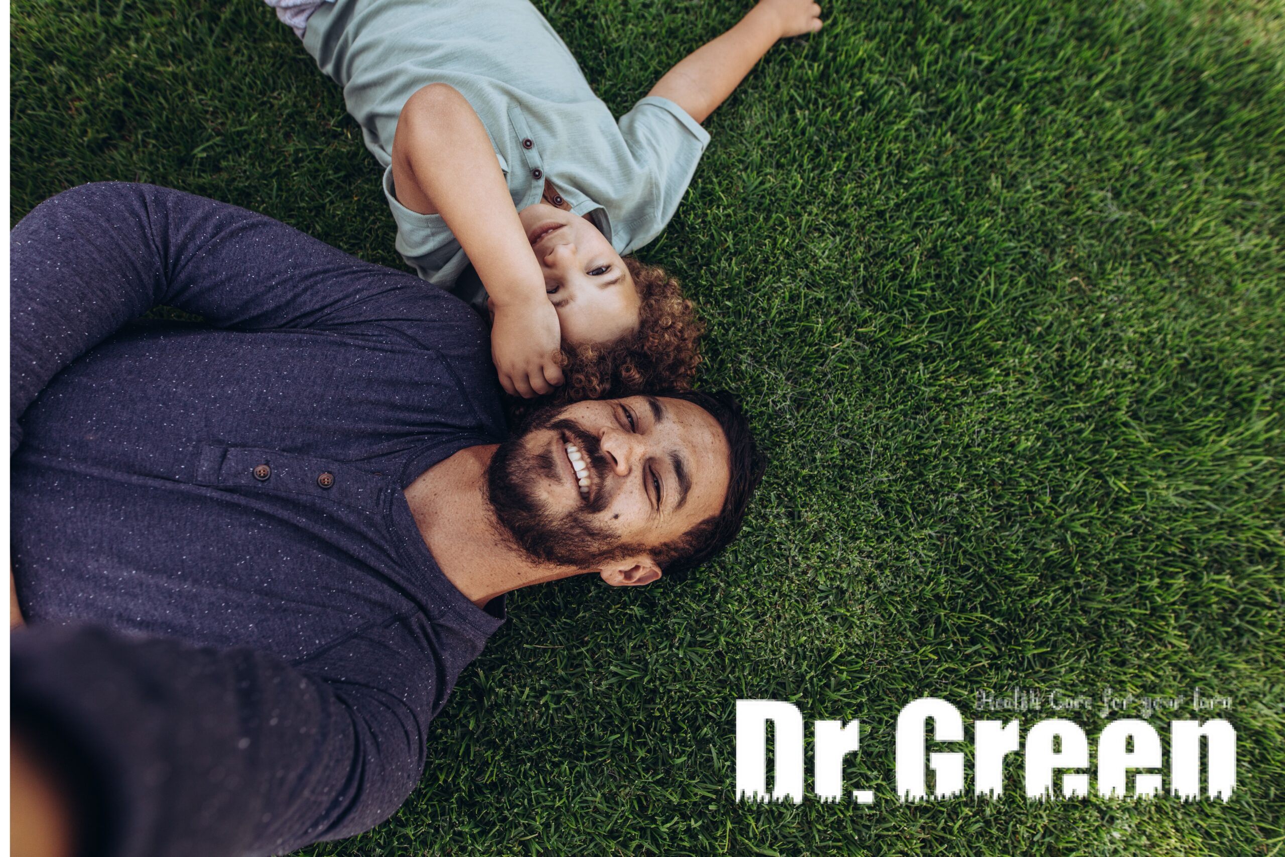 Father and child relaxing on a lush green lawn