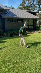 Certified technician at Celina Lawn Care treating a green and weed-free lawn