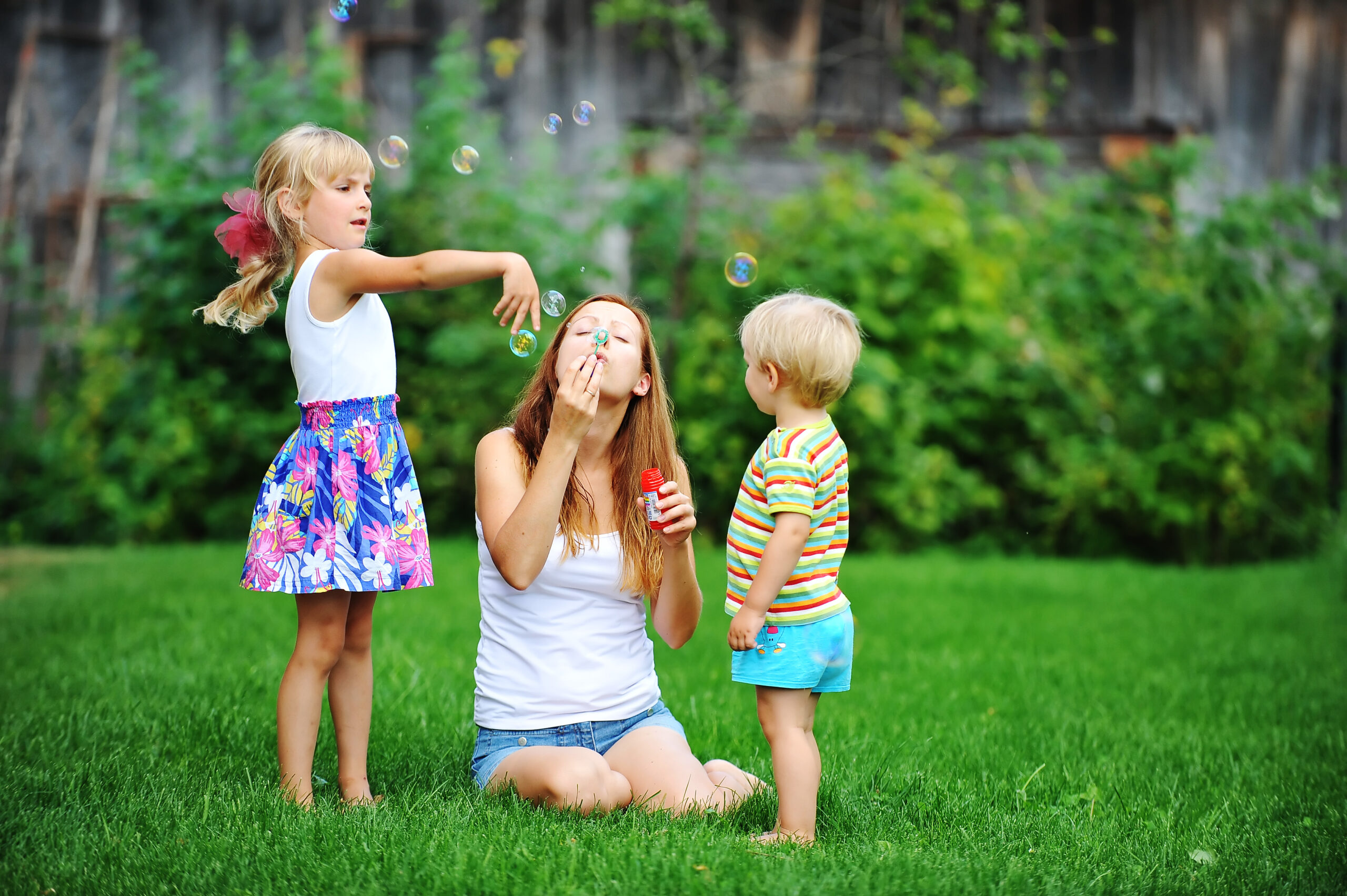 Family enjoying a lush, green, and weed-free lawn maintained by Dr. Green Services.
