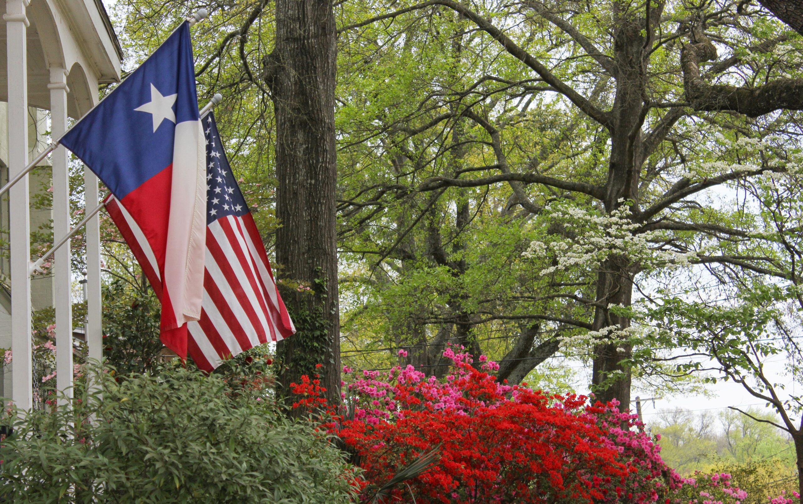 Historical home in Cedar Hill, Texas, with a Texas flag and healthy lawn and trees cared for by Dr. Green Services.