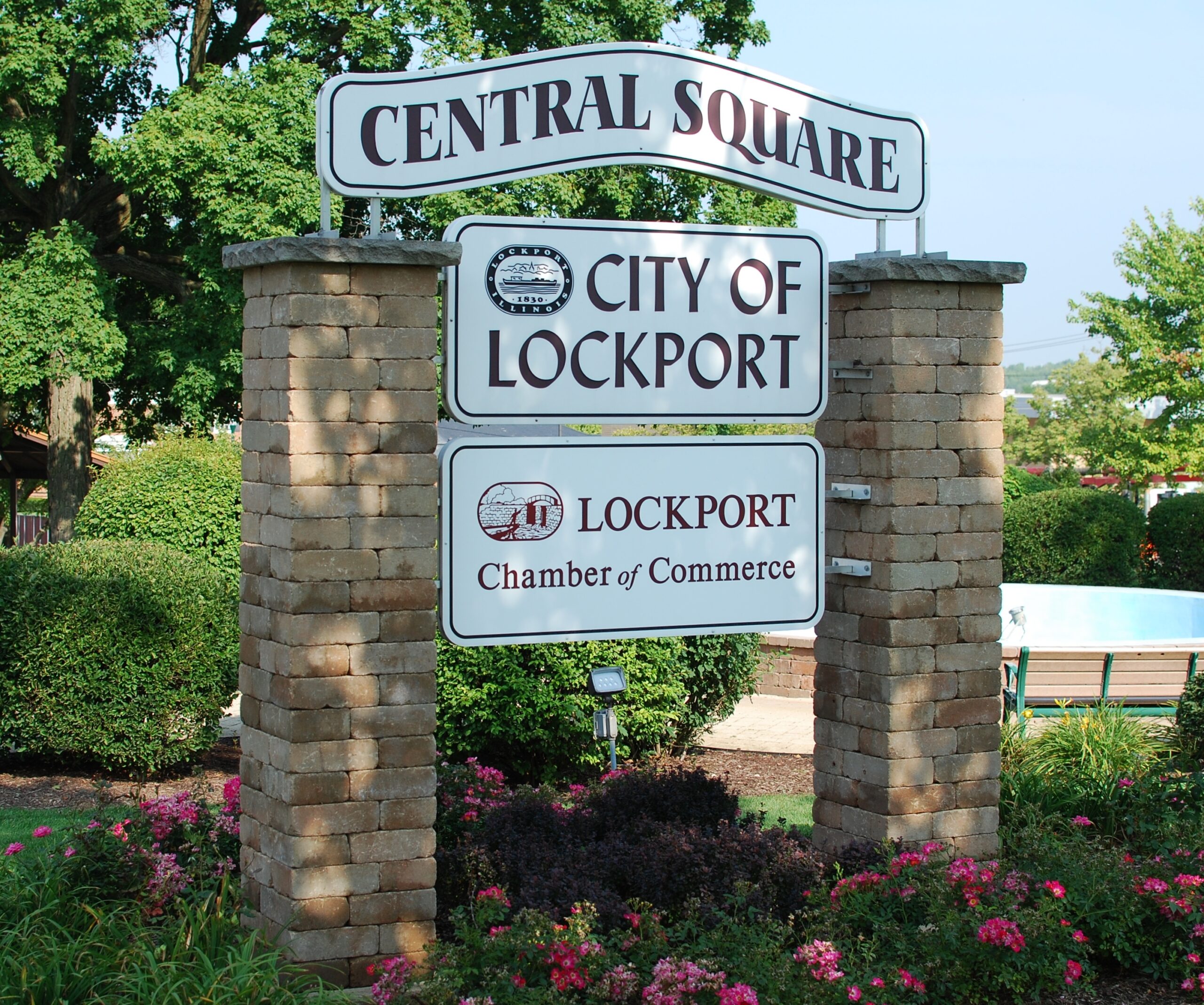 Welcome to Lockport sign surrounded by lush green lawns and vibrant landscaping.