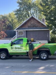 Dr. Green Services Operations Manager overseeing a green and weed-free lawn. Oswego lawn care services ensure healthy and beautiful lawns.