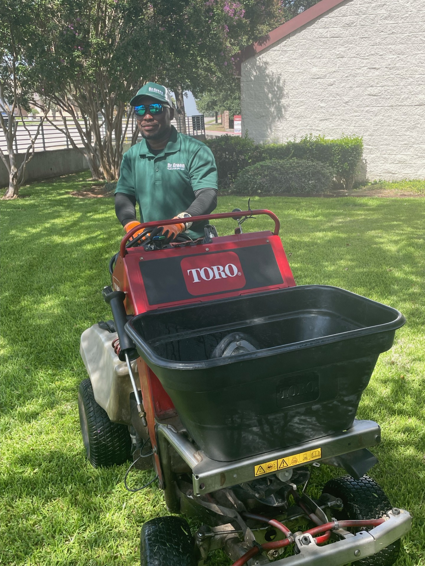 Certified technician inspecting a green and weed-free lawn maintained by Dr. Green Services. Irving lawn care at its best.