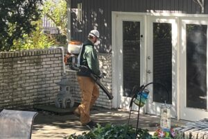 Dr. Green Services technician applying exterior pest control to reduce ticks and other pests in the lawn. 