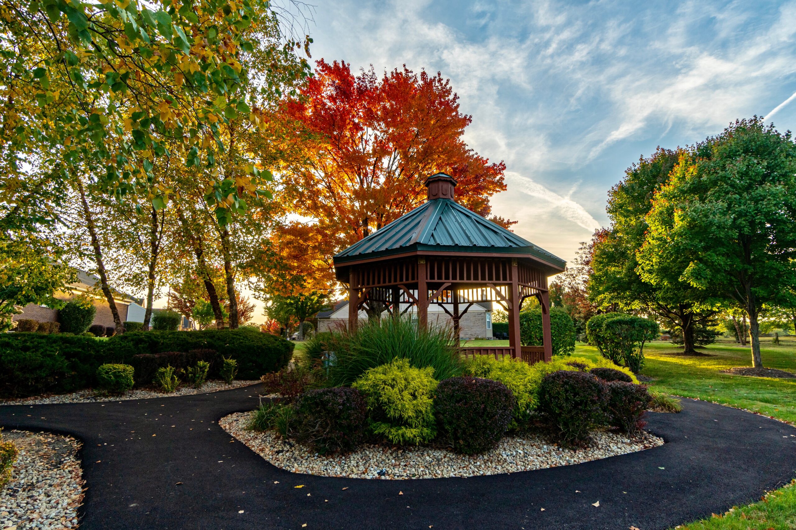 A gazebo in Orland Park during the fall, surrounded by vibrant autumn colors and a green, weed-free lawn maintained by Dr. Green Services.