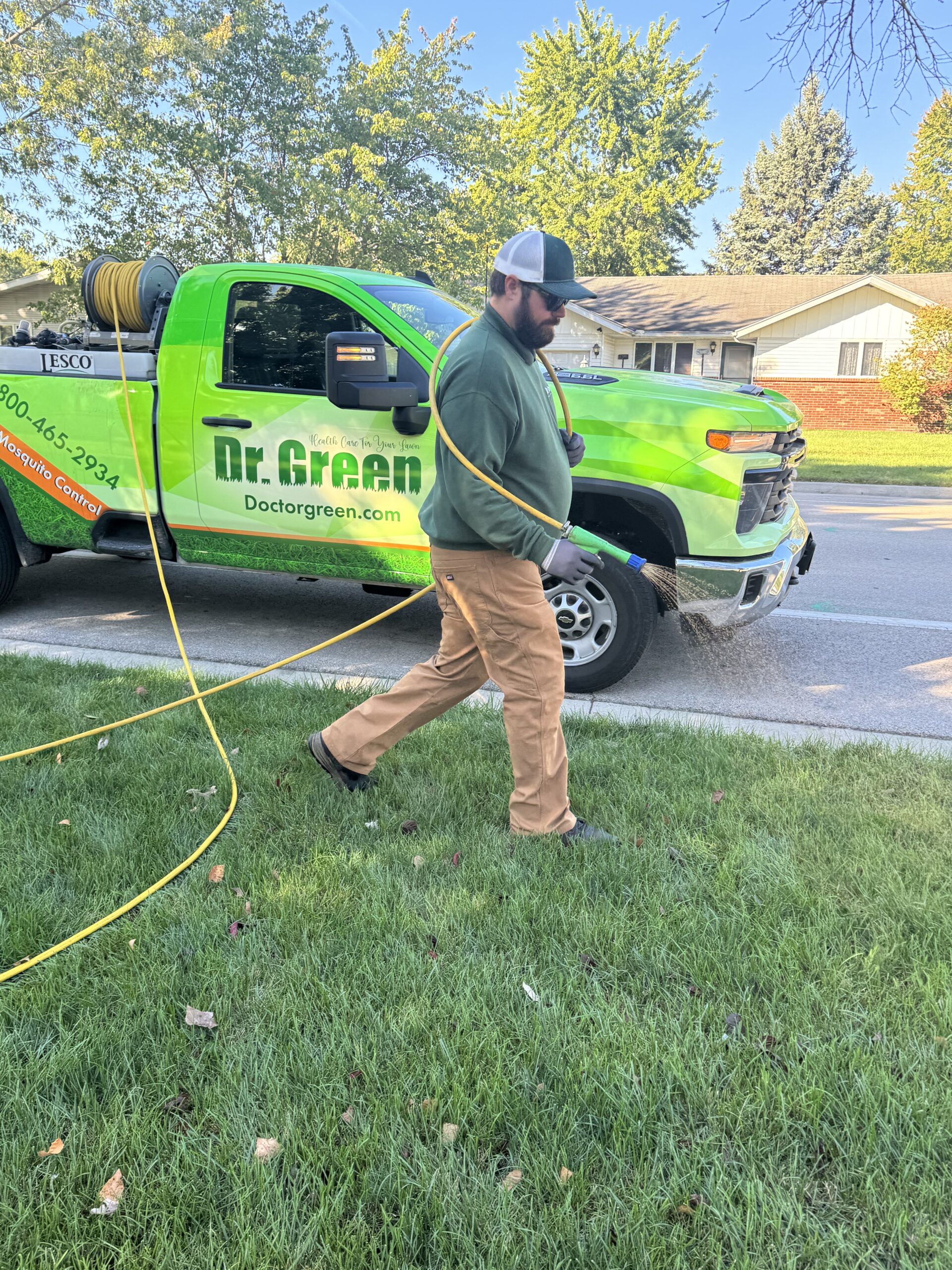Certified technician from Dr. Green Services maintaining a green and weed-free lawn in Romeoville.