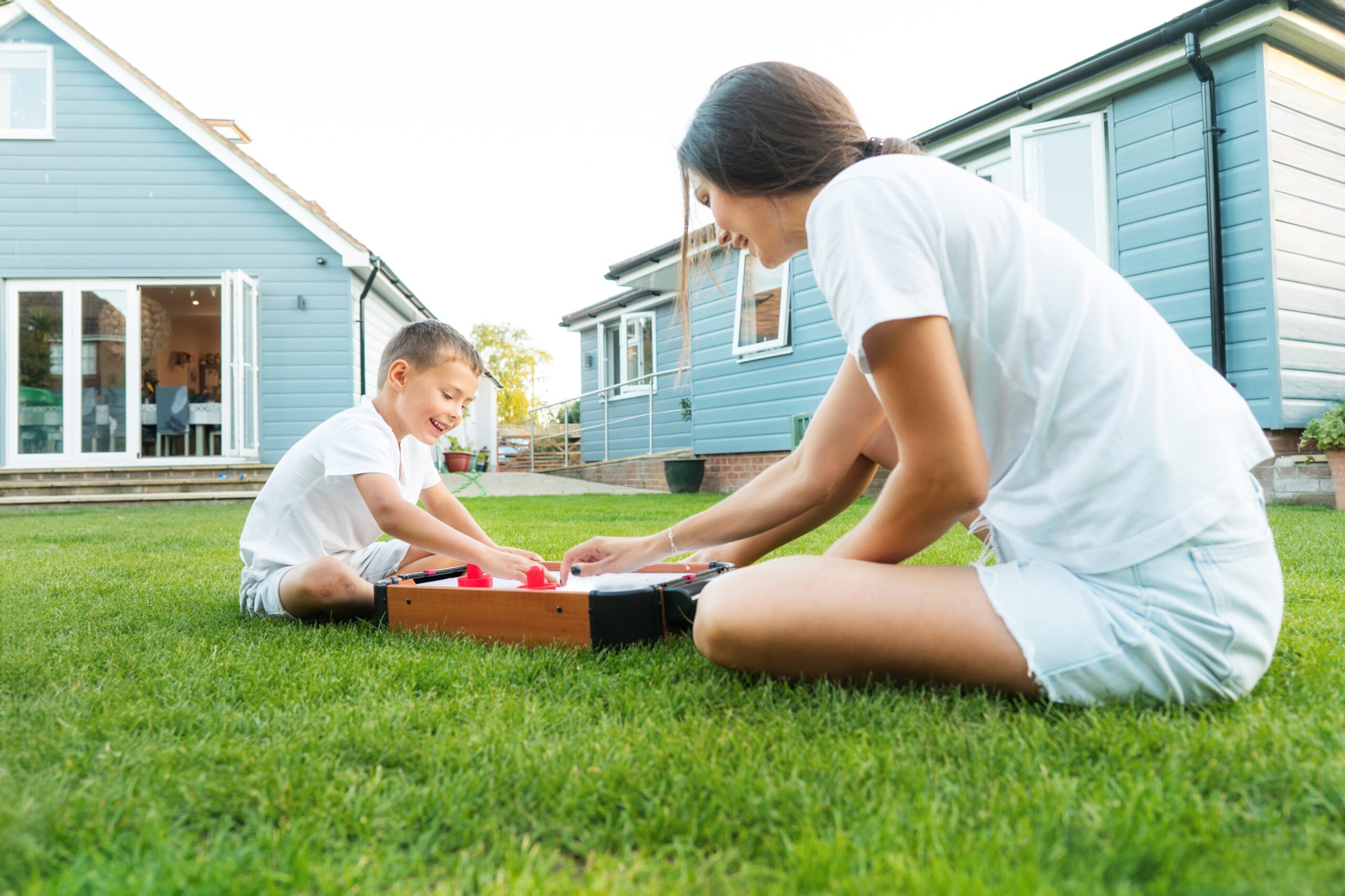 Mother and son enjoying a game together on a lush, green lawn