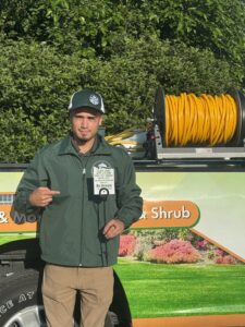 Dr. Green Services technician performing soil health lawn care with liquid aeration and premium fertilizer.